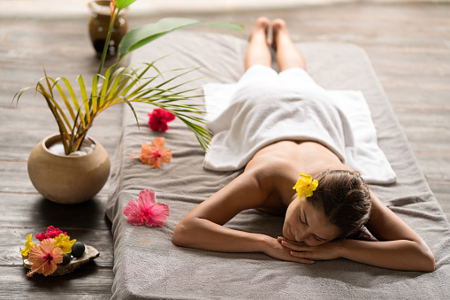 Smiling woman relaxing on a bed at the spa.