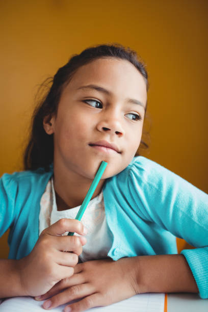 istock Thoughtful girl sitting at a desk 664537044