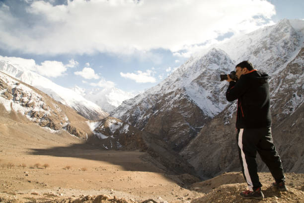 istock Photographer shooting snowcapped Himalayan mountain 664537110