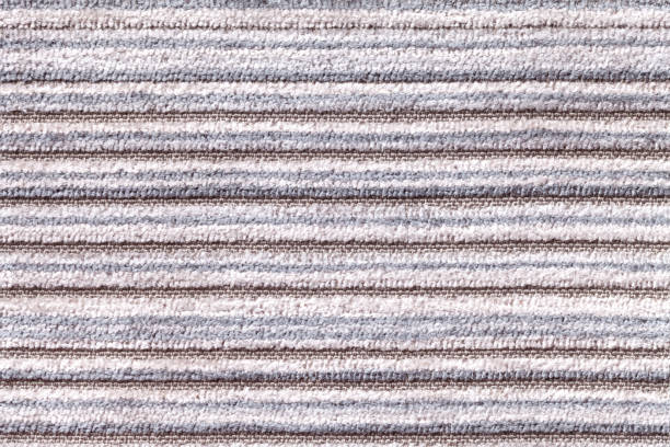 istock Light gray background of a knitted textile material. Fabric with a striped texture closeup. 664538082