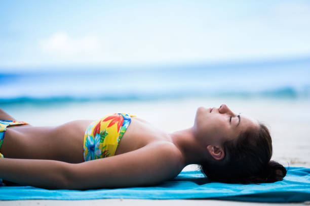 Relaxed woman sunbathing during summer day on the beach.
