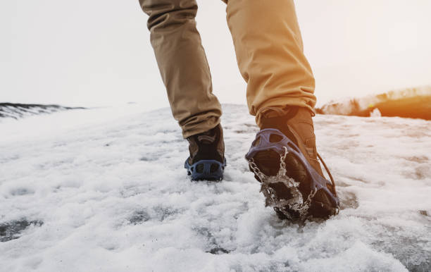 un hombre de senderismo en la montaña de nieve en invierno, con luz solar brillante - bota de la nieve fotografías e imágenes de stock