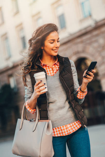 istock Woman texting and drinking coffee outdoors. 664551280