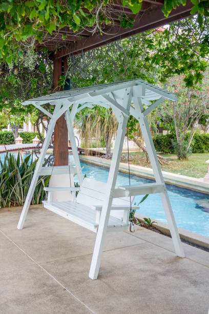 istock white wood swing in green garden 664552912