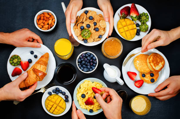 istock Breakfast table setting with flakes, juice, croissants, pancakes and fresh berries 664559540