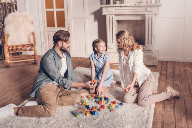 istock happy family playing with constructor and sitting on floor at home 664563328