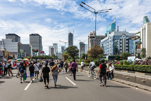 JAKARTA, INDONESIA - DECEMBER 18, 2016: People enjoy outdoor activities, including street food, during the car free day held every Sunday morning in the business district of Jakarta. Only Transjakarta bus can run on the Sudirman avenue.