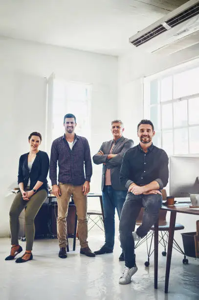 Portrait of a team of creative workers standing together in an office