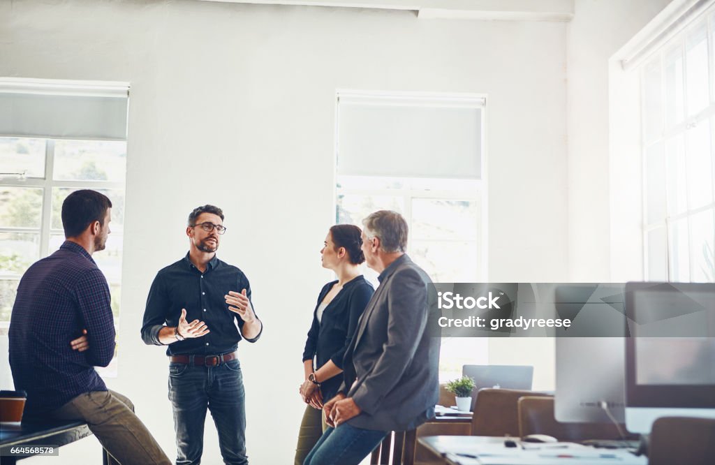 Open your organization to diverse perspectives Shot of a group of designers having a discussion at work Debate Stock Photo