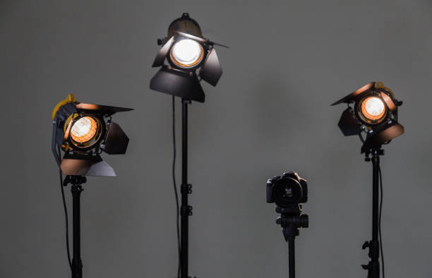istock Digital SLR camera and three spotlights with Fresnel lenses. Manual interchangeable lens for filming. Shooting in the interior with artificial light. Equipment for movies 664572592