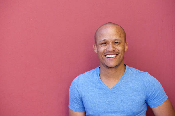 istock handsome african american man smiling against red background 664576776