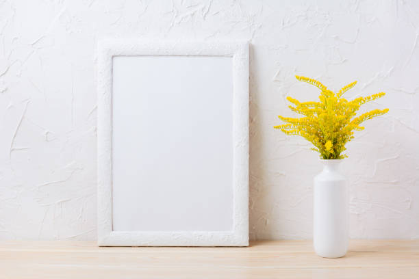 istock White frame mockup with ornamental yellow flowering grass in vase 664581054