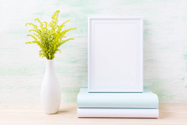 istock White frame mockup with ornamental green grass and books 664581198