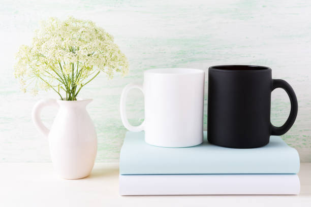 istock White and black mug mockup with books and white flowers 664582346