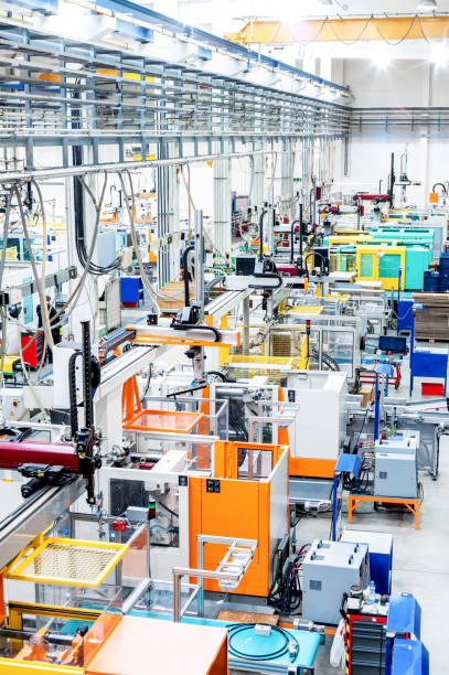 Modern production line with machinery Vertical image of futuristic new factory producing plastic pieces for car industry. Factory modern interior where is placed a lot of robot machines. labor intensive production line stock pictures, royalty-free photos & images