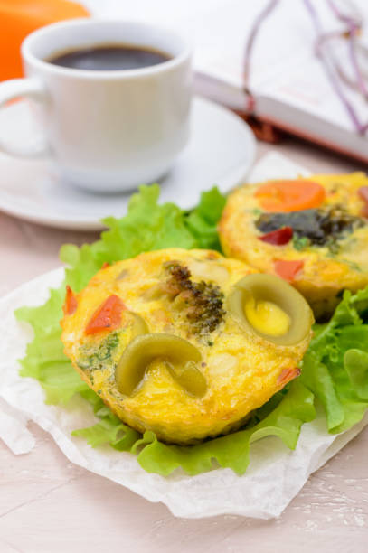 Omelette with colored pasta, mushrooms, vegetables and herbs, cooked in the form of mafins and a cup of espresso. Breakfast.