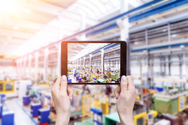 istock Futuristic factory & hands holding tablet 664591408