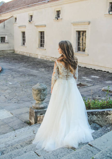 istock Back view of gorgeous bride standing in old stone castle 664594664