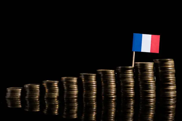 French flag with lot of coins isolated on black background
