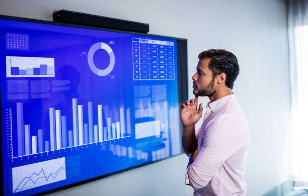 istock Side view of serious man looking at graph on a screen 664599094