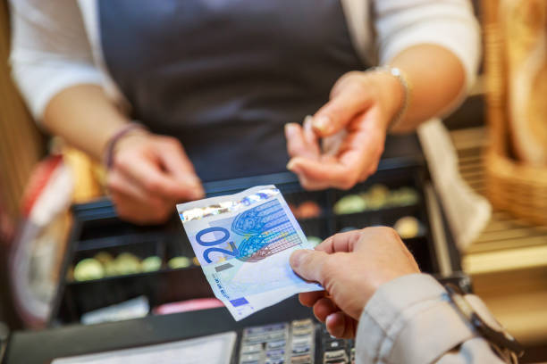 woman is paying In cash with euro banknotes woman is paying In cash with euro banknotes cash register photos stock pictures, royalty-free photos & images