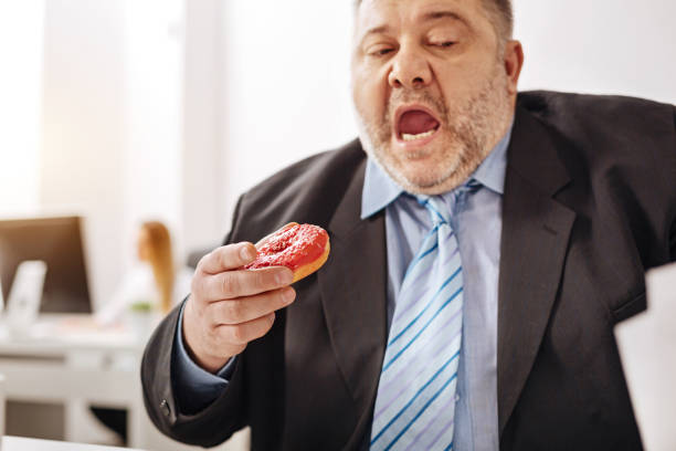 istock Stressed out busy employee enjoying a doughnut 664603348