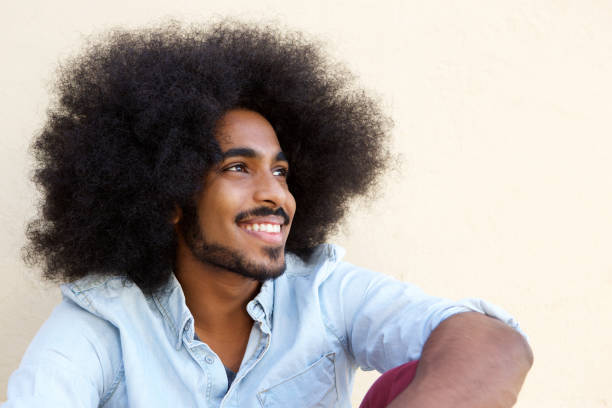 istock happy afro man sitting and looking away 664603420