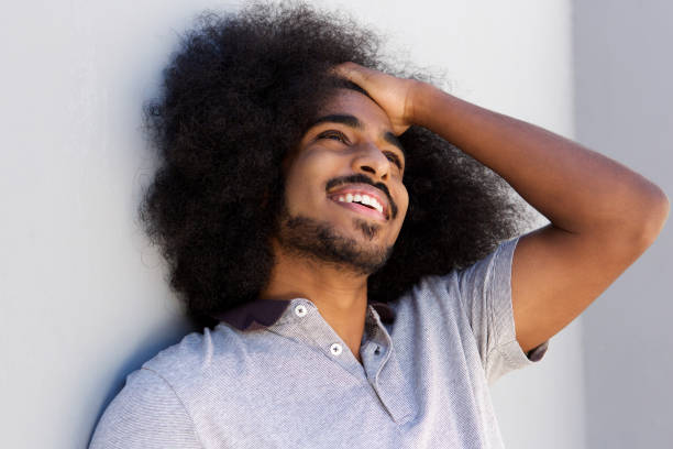 istock laughing afro man with hand in hair looking away 664603468