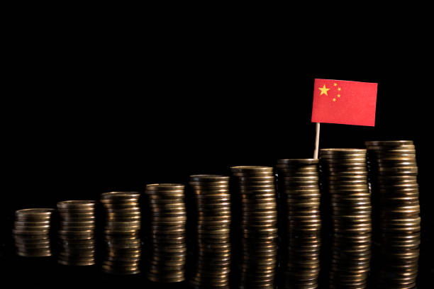 Chinese flag with lot of coins isolated on black background stock photo