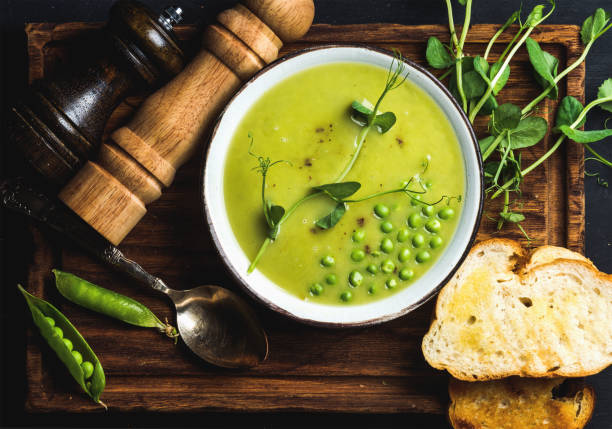 свежий домашний гороховый крем-суп в миске с жареным хлебом - eating utensil green pea vegetarian food organic стоковые фото и изображения