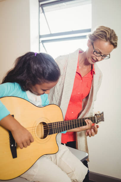 istock Girl learning how to play the guitar 664611414