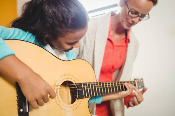 istock Girl learning how to play the guitar 664611438