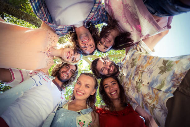 istock Happy friends forming a huddle in park 664615010