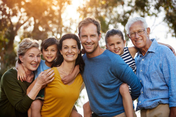This one's for the family photo album Portrait of a family with two young children posing together outside two generation family photos stock pictures, royalty-free photos & images