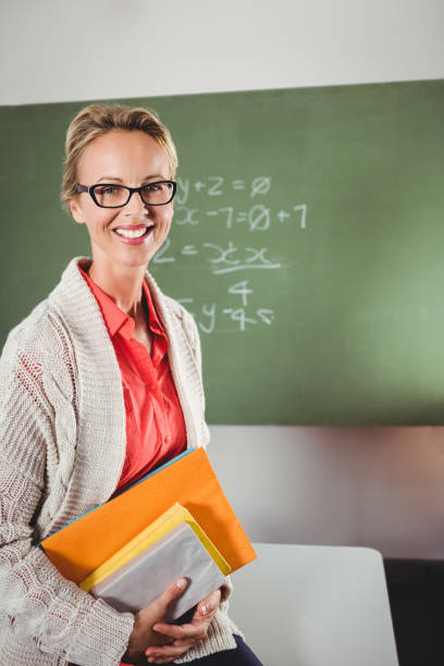 istock Teacher holding books 664617782