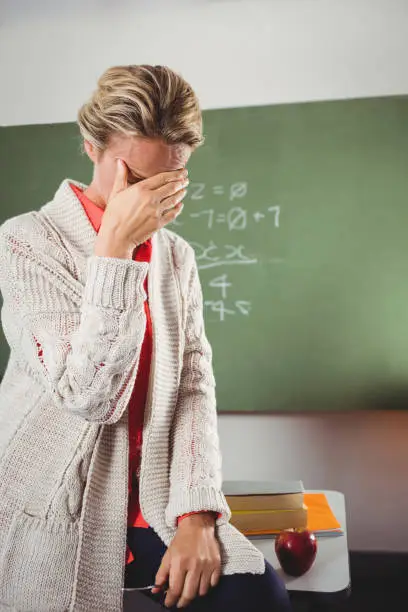 Photo of Teacher crying in front of blackboard
