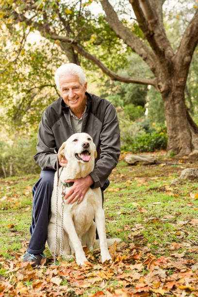 istock Senior man with his dog in park 664618624