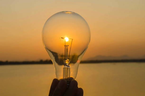 istock concept hand hold lightbulb and sunset background nature idea 664619658