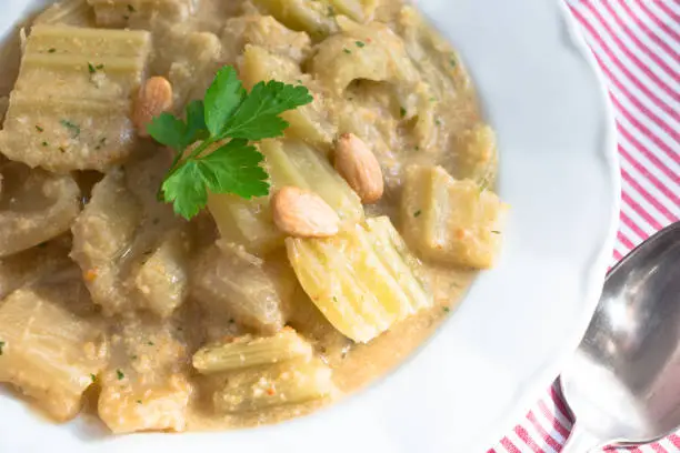 Boiled thistle with almonds sauce and parsley
