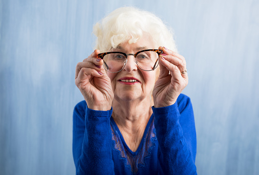 Elderly woman looking through optical  glasses