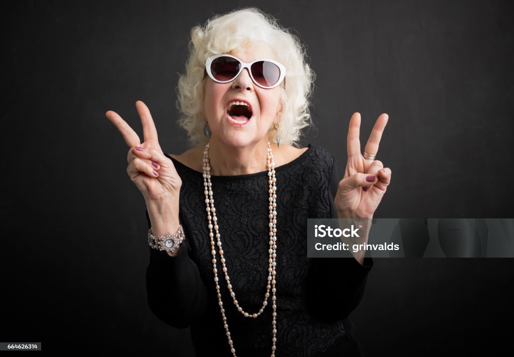 Cool grandmother showing peace sign Cool grandmother with sun glasses  showing peace sign Grandmother Stock Photo