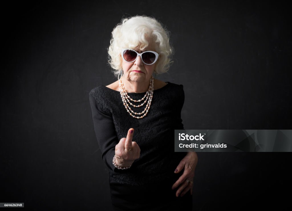 Grandmother flipping people off Grandmother flipping people off with middle finger Senior Women Stock Photo