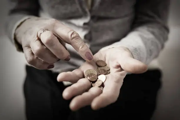 Older person counting coins  in her palm