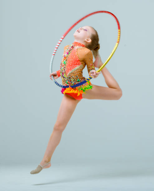 istock Little Rhythmic Gymnast Jumping With Hoop 664627472