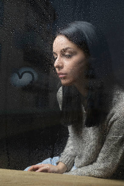 istock Sitting by her window on a rainy day 664631436