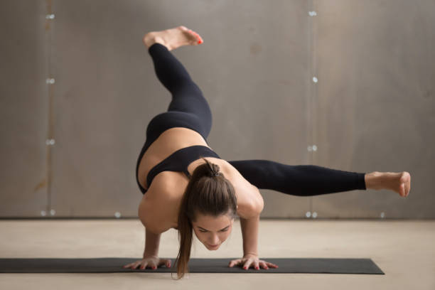 istock Young woman in Eka Pada Koundinyasana 1 pose, grey studio 664637342
