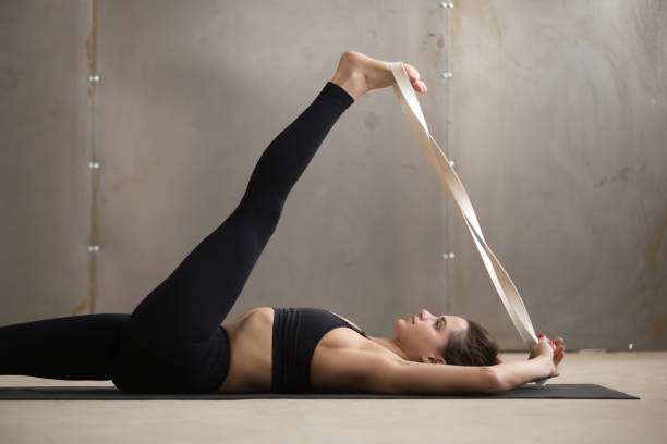 supta padangushthasana, 회색 포즈 스튜디오 backgrou에 젊은 여자 - yoga posture women flexibility 뉴스 사진 이미지
