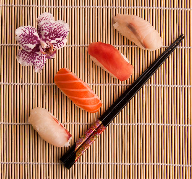 Sushis and chopsticks on a bamboo mat, top  view