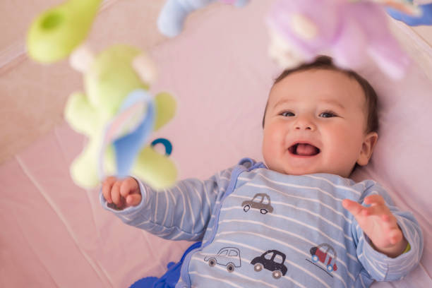istock Happy baby lying in his crib smiling 664642782