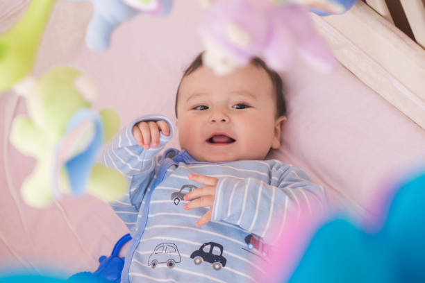 istock Happy baby lying in his crib smiling 664642792